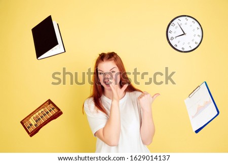 Whispering secrets. Caucasian young woman's portrait on yellow studio background, too much tasks. How to manage time right. Concept of working, business, finance, freelance, self management, planning.