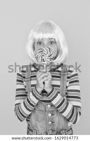 Anime convention. Sweet life. Anime cosplay party concept. Happy little girl. Anime fan. Vibrant character fantastical themes. Modern childhood. Kid with artificial hairstyle eating lollipop.