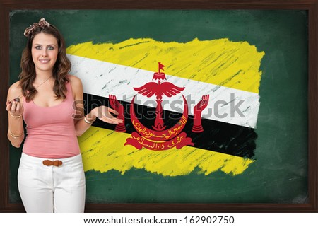 Beautiful and smiling woman showing flag of Brunei on blackboard, presentation for tourism and marketing research