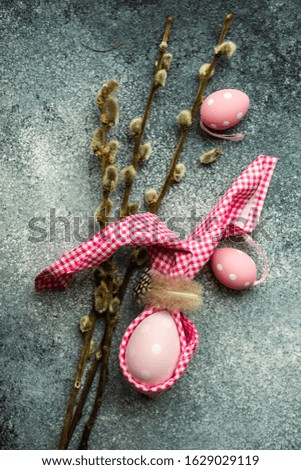 Easter holiday card concept with easter bunny concept with colored eggs on stone background with copy space