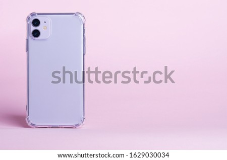 Purple iPhone 11 in clear silicone case back view isolated on pink background. Phone case mock up. Banner with place for text on the right