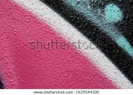 a bright abstract colorful painting on a rough wall