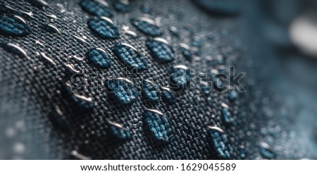 Close-up view on water drops on waterproof impregnated fabric in rain. Royalty-Free Stock Photo #1629045589