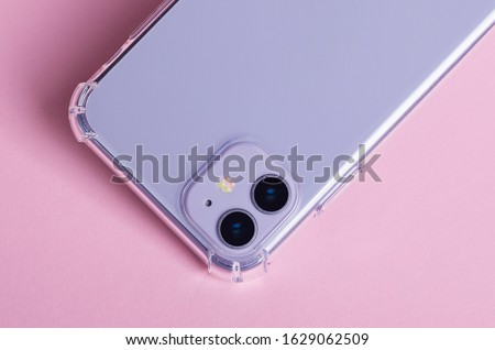 Purple iPhone 11 in clear case isolated on pink background close up back view. Phone case mock up