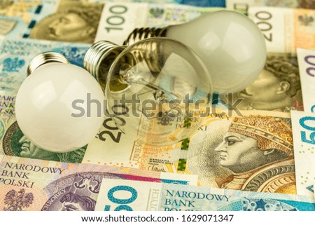 Three light bulbs on background of polish banknotes