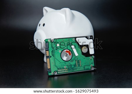 hard disk in piggy bank on black dark background. Business, backup March 31st and technology concept. Backup day. Copy space for text. HDD hard drive