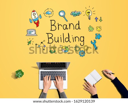 Brand building with people working together with laptop and notebook