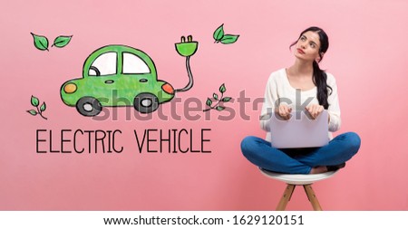 Electric car with young woman using a laptop computer