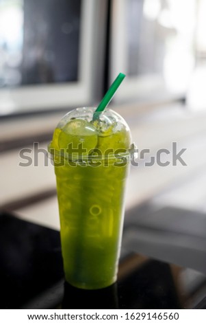 Green tea with lemon in plastic glass.