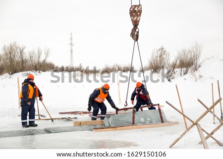 Slingers pull ice panels out of the lane using a truck crane