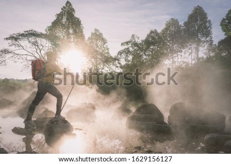 Happy tourists having fun with travel amid morning fog over hot spring at Chae Sorn National Park, Thailand