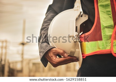 Close up hand holding white helmet hard hat Engineering concept Royalty-Free Stock Photo #1629158851