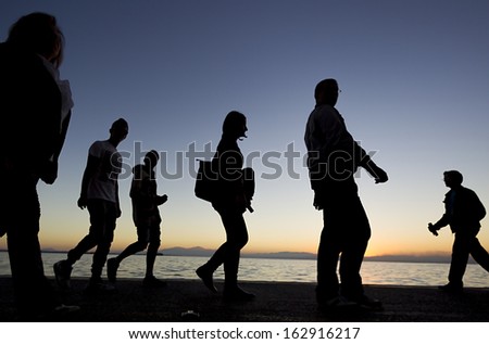 Silouetes of people walking on the sunset 
