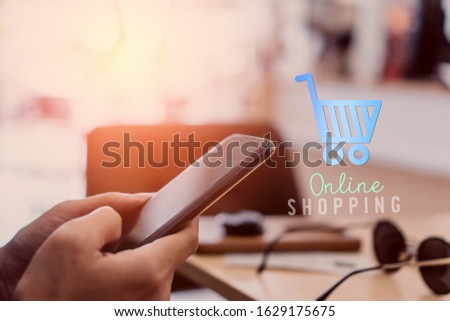 Women hand using smartphone do online business or shopping online in black friday with cart, dollar icons pop up in public area background. Social media maketing concept.