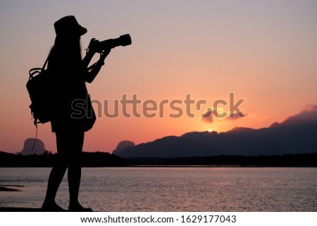 Silhouette woman take a picture on mountain and sea in the pastel morning background