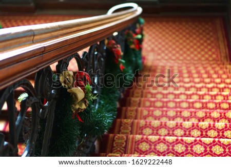 Wooden vintage stairs with Christmas decoration and red carpet
