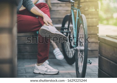 Young man in red pants next to the track bike