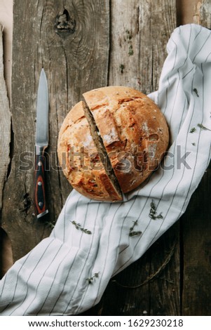 Baking on a towel with garlic and oil. A loaf of white rye bread. Sliced bread on a wooden background. 