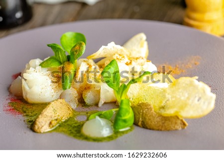 rustic wooden background, top and side, on a plate, halibut fish appetizer, olive tapenade, croutons, greens and vegetables