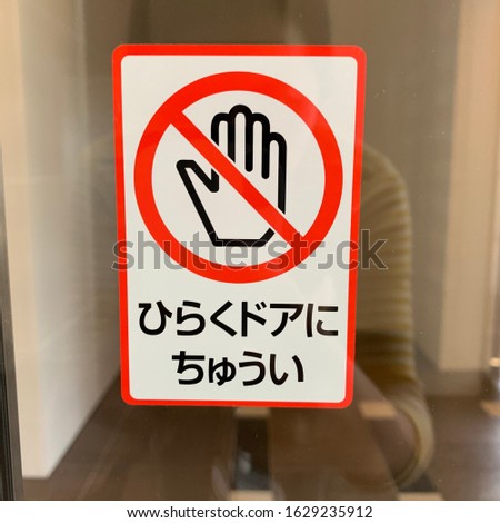 Do not touch sign while the door is open.