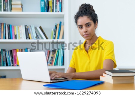 Beautiful brazilian female student learning at computer at university
