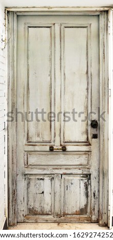 Old worn white door damaged and with ancient texturee from an abandoned building