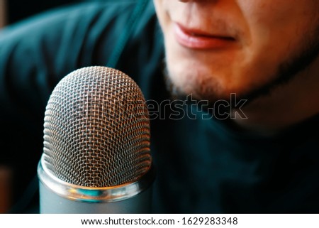 A person is broadcasting on the air on a microphone. Podcast studio.