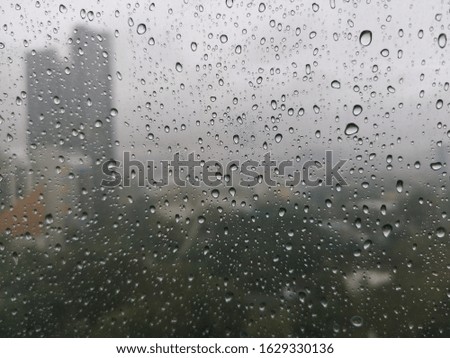 Rain water on window glass with fuzzy background