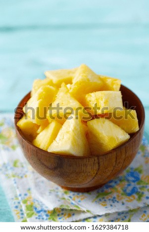 fresh pineapple pieces on turquoises wooden surface