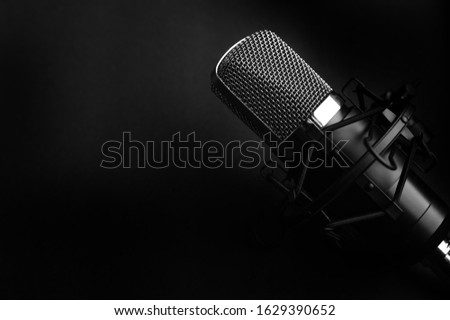 Condenser black studio microphone on a black background. Streamer, podcasts, music background