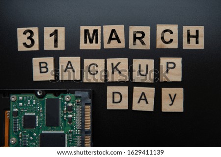 hard disk on black dark background with selective focus and crop fragment. Business, backup March 31st and technology concept. Words in English Backup day. Copy space for text. HDD hard drive