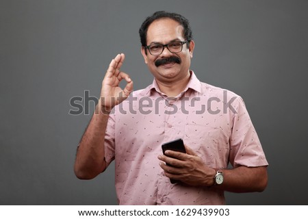 Middle aged man of Indian origin shows a satisfaction gesture Royalty-Free Stock Photo #1629439903