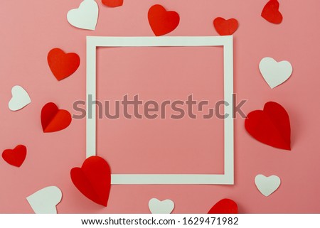 Table top view image of decoration valentine's day background concept.Flat lay arrangement of red shape & gift box with essential items on modern rustic pink paper with middle space for mock up design