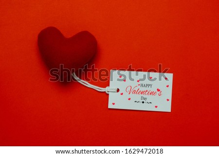 Table top view aerial image of decoration valentine's day background concept.Flat lay arrangement of word season tag & essential items love heart on modern rustic red paper for mock up creative design