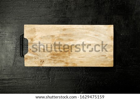 Flat photo of kitchen background and free space for your decoration.Black stone top and wooden board with empty place for your decoration. 