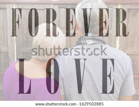 The word "FOREVER LOVE" on Senior Couple snuggle photo background, Valentine concept.