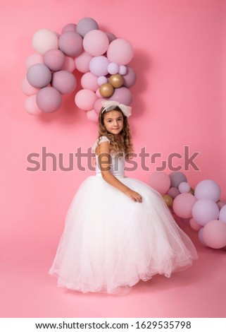 Cute girl with balloons on pink background 