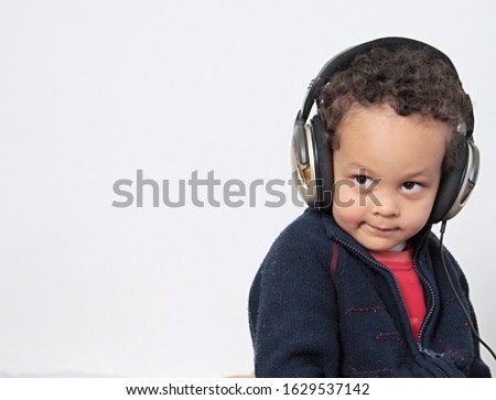 boy listening to his headphones with music coming through on white background stock photo