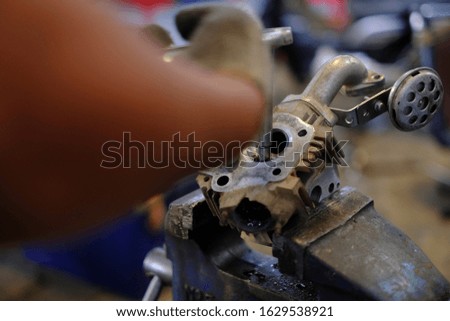 Motorcycle mechanic repairing engine cylinder heads of motorcycles