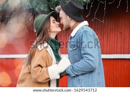 Happy young couple on Christmas fair outdoors