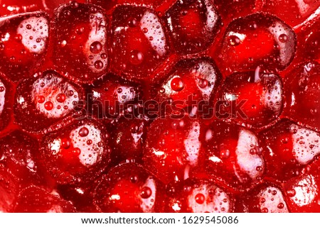 Pomegranate seeds close up background. Texture water drops on exotic fruit. Royalty-Free Stock Photo #1629545086