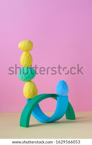Easter minimalistic decor concept. Geometric Easter eggs standing on top of each other on pink background with blank space for text.