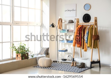 Interior of modern dressing room with winter clothes