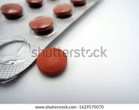 Tablets of iron in a blister, one pill out of the blister           Royalty-Free Stock Photo #1629570070