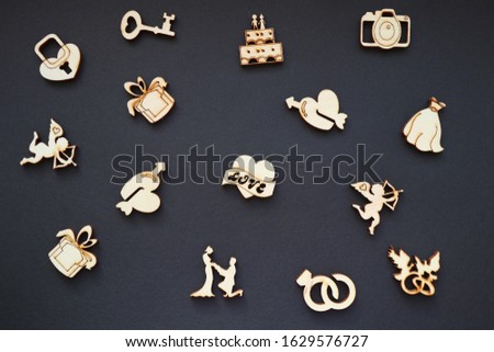 Wooden figures with symbols of love on a black background.