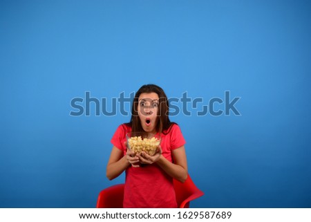 Woman with popcorn sitting on the chair seat free advertising