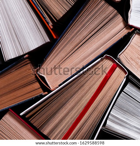 Books. Lots of colourful thick open books stand on a dark background