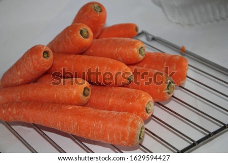 Fresh carrots pile on cooling rack 