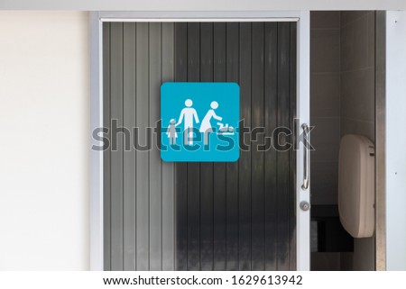 baby changing station room. family toilet room sign on door.