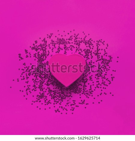 Red gift box in the shape of heart and confetti on pink background top view Flat lay. Creative composition for Valentine's Day, love concept, birthday present, mother day, March 8, holiday background